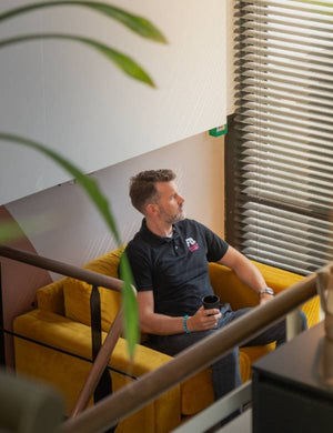 Man geniet van een kop koffie op een sofa